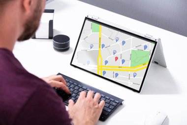 Dizüstü bilgisayarında GPS Haritası kullanarak yön bulma noktalarını kullanan bir adamın yakın çekimi