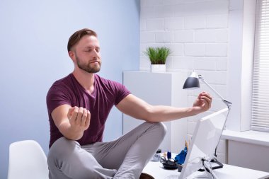 Ofiste Resepsiyon meditasyon üzerinde oturan genç işadamı