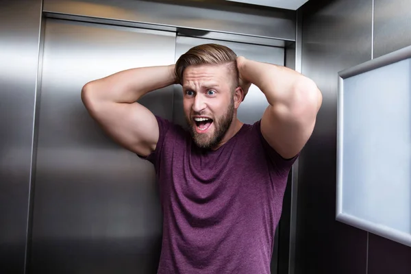 エレベーターの中に閉じ込められた閉所恐怖症に苦しむ男性の叫び声 — ストック写真