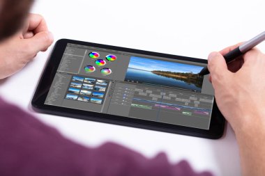 Genç erkek editör işyerinde tablet video düzenleme