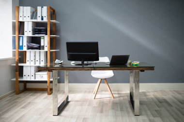 Modern İç Ofis'te Masa Başında Bilgisayar ve Dizüstü Bilgisayar