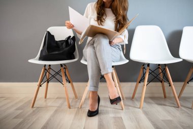 Genç İş Kadını İş Görüşmesi Ni Beklerken Sandalyede Otururken Klasörü Tutuyor