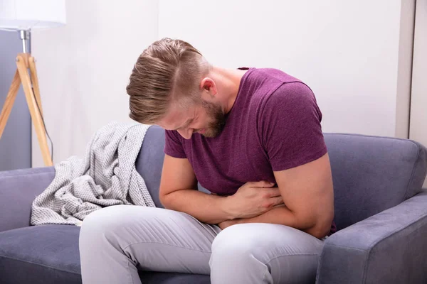 Hombre Joven Que Sufre Dolor Estómago Sentado Sofá Casa — Foto de Stock