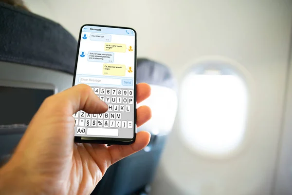 Zbliżenie Osoby Ręczne Pisanie Wiadomości Sms Telefon Komórkowy Samolocie — Zdjęcie stockowe