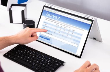 Yakın çekim bir işadamı el laptop Office online anket formu doldurma