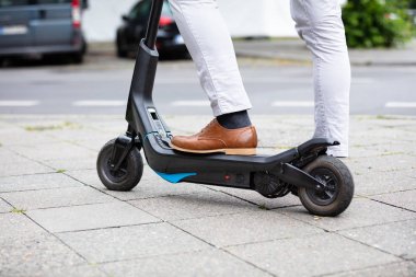 Sokakta Elektrikli Scooter Üzerinde Duran Bir İşadamı nın Düşük Bölümü