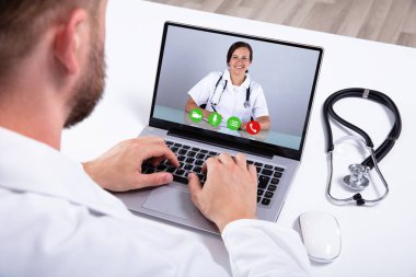 Doktor iş arkadaşlarıyla dizüstü bilgisayarda video konferansı yapıyor.