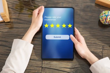 İş Kadını Ofiste Dijital Tablet Kullanarak Masa Üzerinden Online Web Sitesi ile Derecelendirme Göndermek için