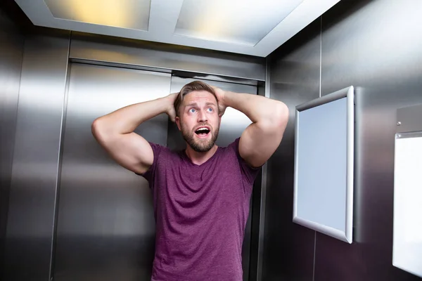 男子遭受克劳斯恐惧症被困在电梯内尖叫 — 图库照片