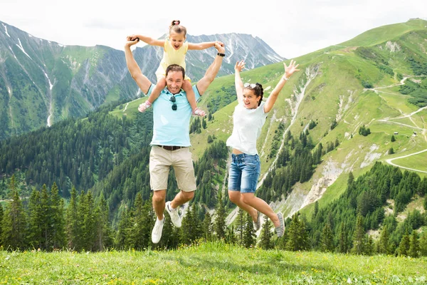 快乐的家庭与小女孩在夏天在奥地利山区跳跃 — 图库照片