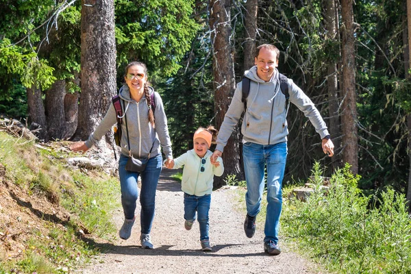 Family Running In Forest In Mountains In Summer