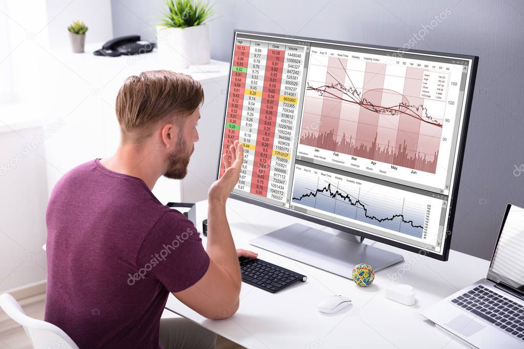Despairing Businessman Faced With Financial Losses Looking On Graphs Dropping Into The Red