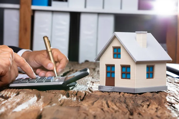 Close Modelo Casa Frente Mão Empresário Usando Calculadora — Fotografia de Stock