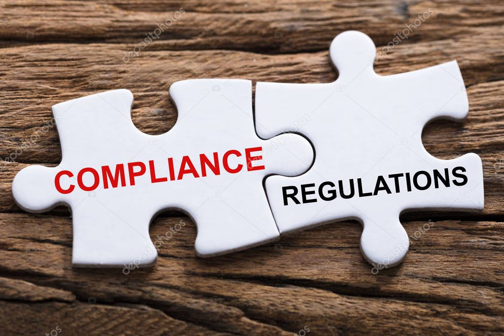 An Elevated View Of Compliance And Regulations Word Written On Pieces Of Jigsaw Puzzle