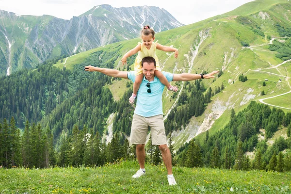 Kız ve baba dağlarda eğleniyorlar. Avusturya, Alpler