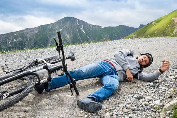 山地自行车发生事故后躺在地上的男子 — 图库照片