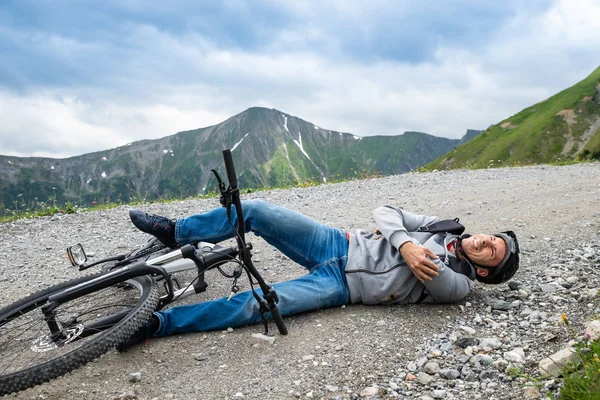 山地自行车发生事故后躺在地上的男子 — 图库照片