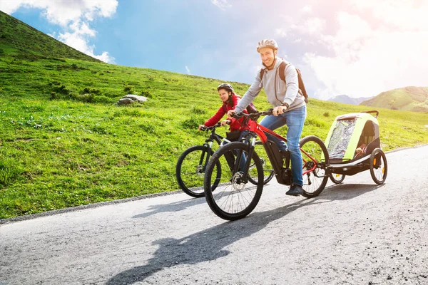 家庭与孩子在拖车骑山地自行车在阿尔卑斯山 — 图库照片