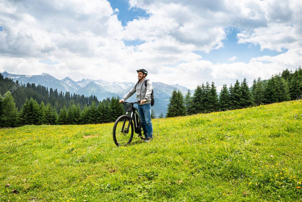 Man On Mountain With His Bike In Alps