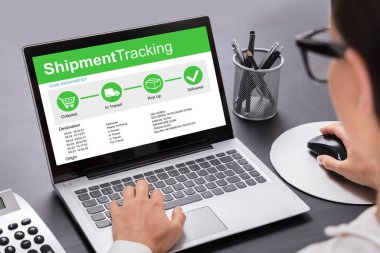 Laptopta Çalışan İş kadınının Masa Başında Sevkiyat Takip Seçeneklerini Göstermesi
