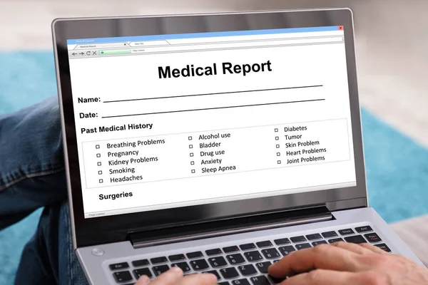 Man Filling Patient Information Form On Digital Laptop