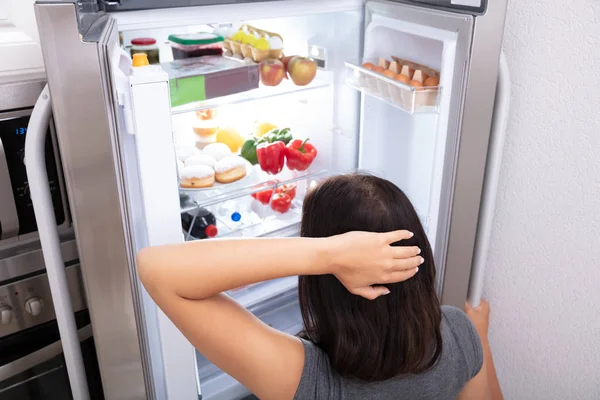 Збентежена Жінка Шукає Їжу Відкритому Холодильнику — стокове фото
