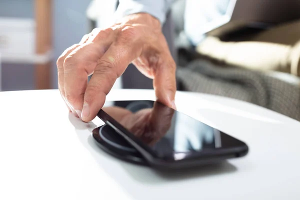 Man Laddning Smartphone Använda Trådlös Laddning Pad Hemma — Stockfoto