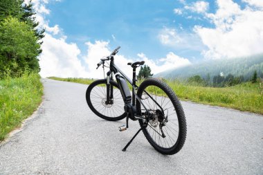 Electric Mountain Bike On Road In Austrian Mountains  clipart