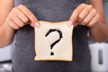 Soru İşareti İşareti ile Dilimlenmiş Ekmek Tutan Bir Kadın Eller Orta Bölümü
