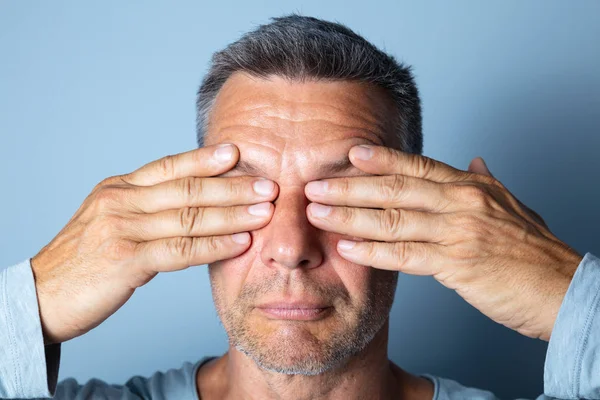 Mature Man Massaging Eyes. Doing Eye Exercises to Improve Eyesight