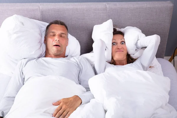 Mature Woman Covering Her Ears Cushion While Man Snoring Bed — Stock Photo, Image