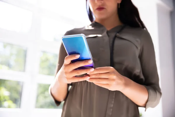 Joven Mujer Negocios Usando Smartphone Mientras Está Pie Oficina —  Fotos de Stock