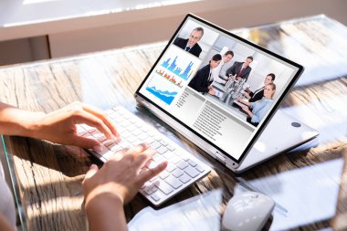 Cropped Image Of Businesswoman Using Laptop At Desk For Video Conferencing clipart