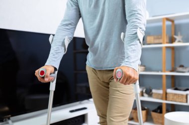 Evde Yürümek Için Koltuk Değneklerini Kullanan Engelli Adam