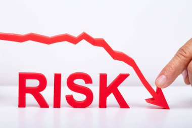 İşadamı Masa Daki Risk Metni nin Üzerine Kırmızı Azalan Ok Gösteriyor