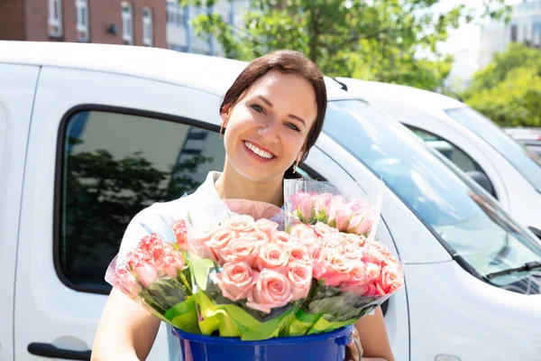車の前でピンクの花束を持つ幸せな女性花屋の肖像画 — ストック写真