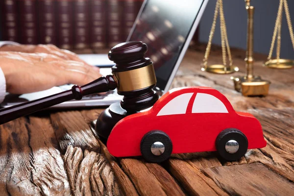 Red Car Front Gavel Mallet Businessperson Using Laptop — Stock Photo, Image