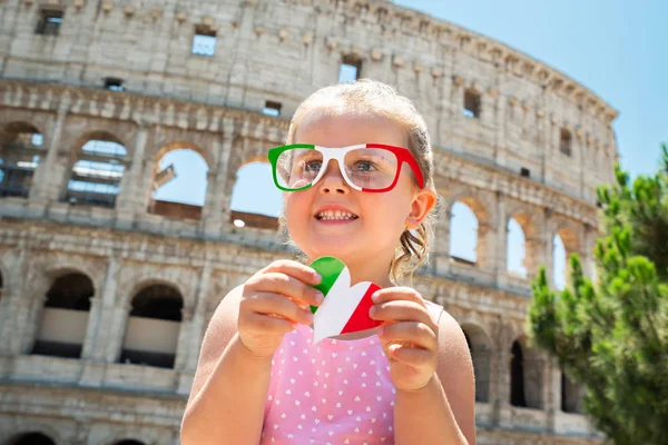 Chica Turista Vistiendo Gafas Sol Bandera Italiana Sosteniendo Corazón Frente —  Fotos de Stock