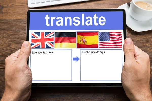 人的手握住数字平板电脑显示语言翻译应用程序与国家标志 — 图库照片