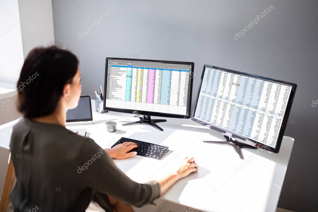 Side View Of Businesswoman's Hand Analyzing Data On Computer Over Desk