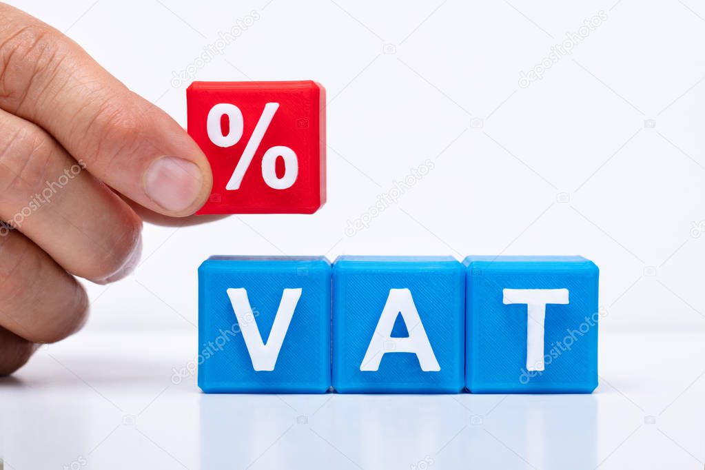 Person's Placing Red Percentage Block Over Vat On White Background