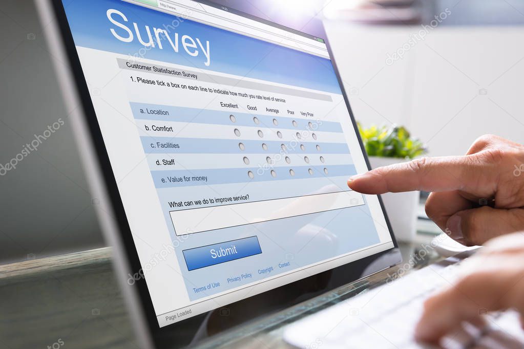 Close-up Of A Businessman Filling Survey On Laptop At Workplace