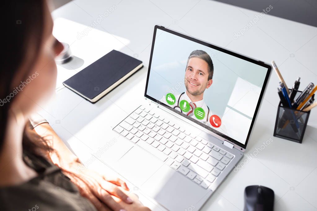 Young Female Video Chatting With Doctor On Laptop