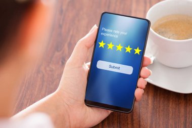 İş kadını Ahşap üzerinden online web sitesi ile derecelendirme göndermek için restoranda cep telefonu kullanma
