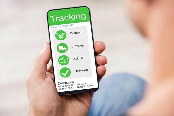 Defocused Osoba Trzyma Smartphone Aplikacją Pokazując Przesyłki Śledzenia Ekranie — Zdjęcie stockowe