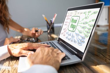 Close-up Of Two Businesspeople Making Mind Map On Laptop clipart