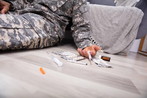 Şırınga ve Blister Paketlenmiş Pills Evde Disables Ordu Subayı Yakın Yere Fallen