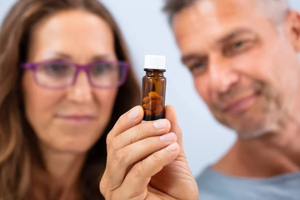 Älteres Paar Blickt Auf Verschlossene Flasche Gefüllt Mit Pillen — Stockfoto