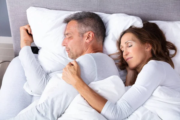 白い毛布でベッドの上で眠る成熟した愛情のカップル — ストック写真