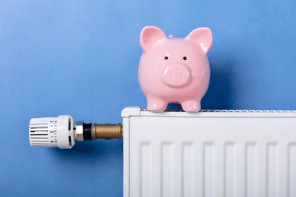 Piggy Bank Verwarmings Radiator Met Temperatuurregelaar Tegen Blauwe Achtergrond — Stockfoto